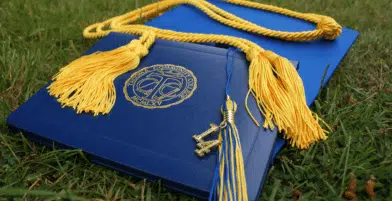 Canva - Diploma and Square Academic Hat on Grass Field